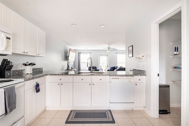 1477 N Donahue Dr N Unit 1602, Auburn, AL 36830 - kitchen with white appliances, a sink, a ceiling fan, white cabinets, and dark stone counters