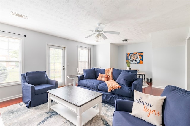 1477 N Donahue Dr N Unit 1602, Auburn, AL 36830 - living area featuring wood finished floors, baseboards, a ceiling fan, and a textured ceiling