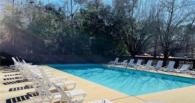 pool with a patio area and fence