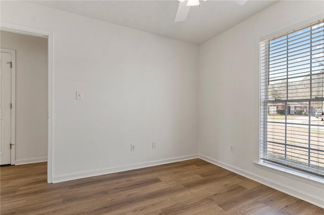 unfurnished room with a ceiling fan, baseboards, and wood finished floors