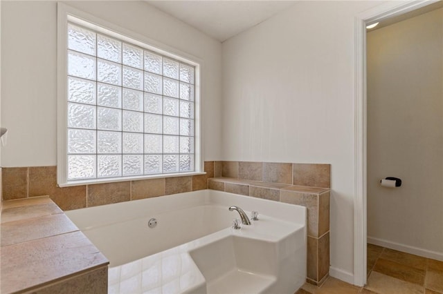 full bath with a garden tub and baseboards