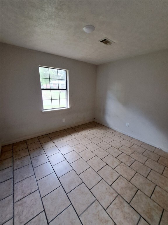 2106 Auburn St, Tuskegee, AL 36083 - spare room with light tile patterned floors and visible vents