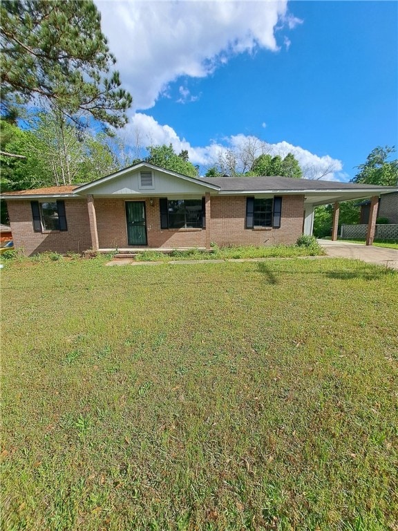 2106 Auburn St, Tuskegee, AL 36083 - ranch-style home featuring concrete driveway, an attached carport, brick siding, and a front yard