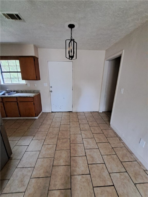 2106 Auburn St, Tuskegee, AL 36083 - unfurnished dining area featuring a sink, a textured ceiling, and visible vents