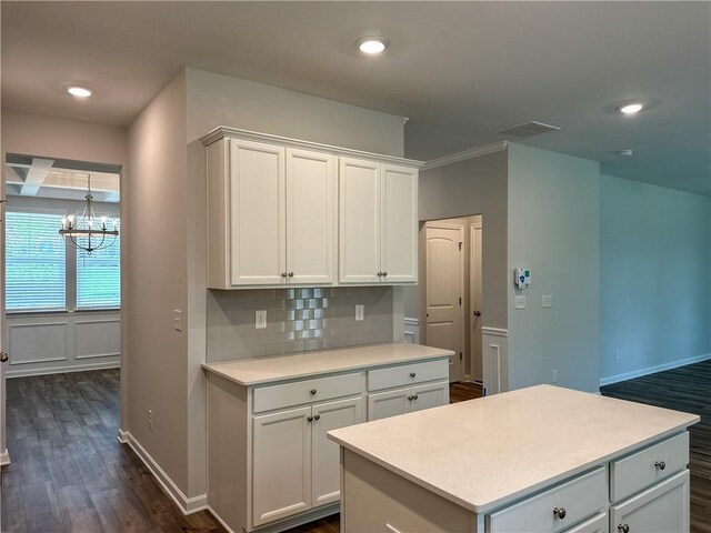 2113 Covey Dr, Auburn, AL 36879 - kitchen featuring dark wood-type flooring, light countertops, backsplash, white cabinetry, and a chandelier