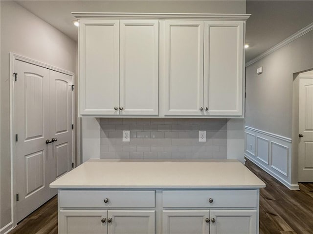 room details featuring ornamental molding, decorative backsplash, wood finished floors, and wainscoting