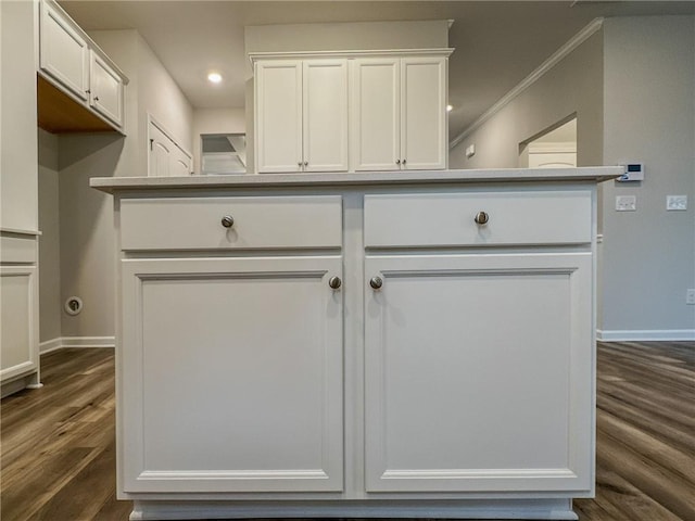 kitchen with dark wood-style floors, ornamental molding, white cabinetry, and baseboards