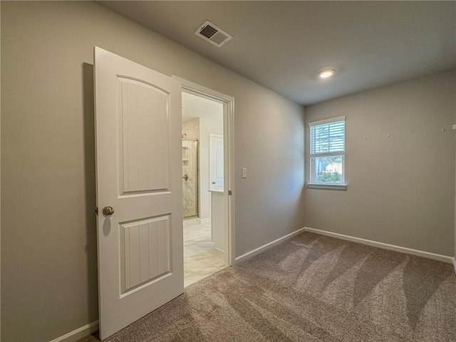 carpeted empty room with visible vents and baseboards