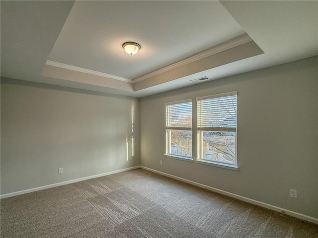 unfurnished room featuring a tray ceiling, visible vents, and baseboards