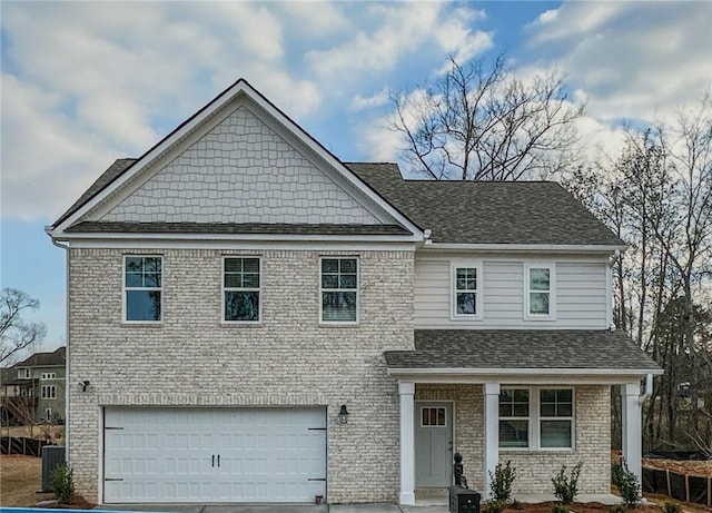 craftsman-style home featuring concrete driveway, roof with shingles, an attached garage, central air condition unit, and brick siding