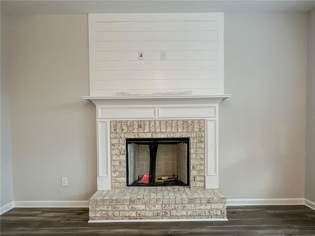 room details featuring a fireplace, baseboards, and wood finished floors