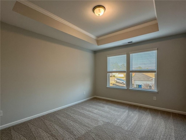 empty room featuring carpet, a raised ceiling, visible vents, and baseboards