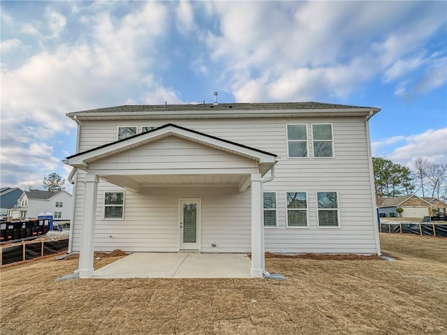 rear view of property featuring a patio, a lawn, and fence