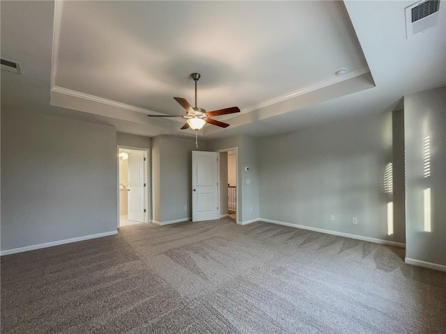 interior space featuring ceiling fan, a tray ceiling, visible vents, and baseboards