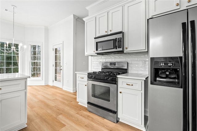 1756 Vfw Rd, Auburn, AL 36832 - kitchen with appliances with stainless steel finishes, crown molding, light countertops, tasteful backsplash, and a chandelier