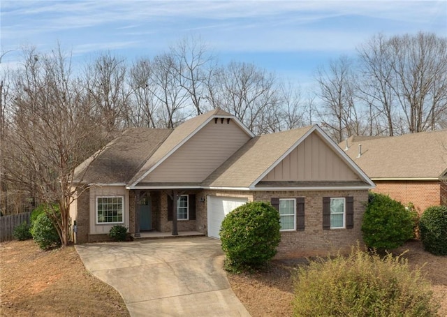 1756 Vfw Rd, Auburn, AL 36832 - view of front facade with brick siding, a garage, driveway, board and batten siding, and roof with shingles