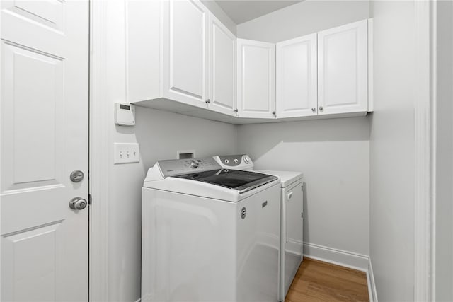 1756 Vfw Rd, Auburn, AL 36832 - laundry area featuring independent washer and dryer, cabinet space, and light wood-style floors