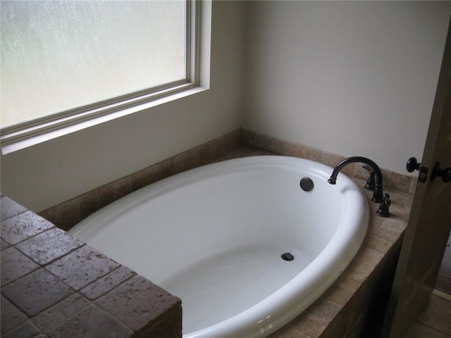 bathroom with a relaxing tiled tub