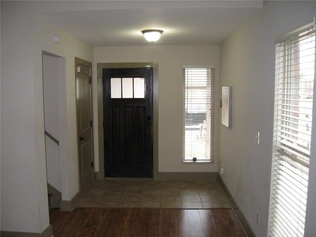 entryway with dark hardwood / wood-style flooring and a healthy amount of sunlight