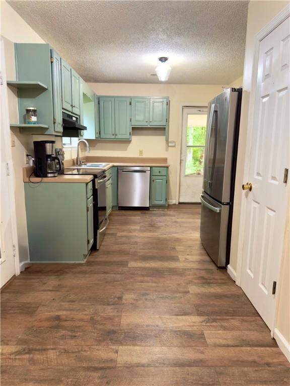 5755 Lee Road 390, Opelika, AL 36804 - kitchen with stainless steel appliances, a textured ceiling, under cabinet range hood, open shelves, and dark wood-style floors