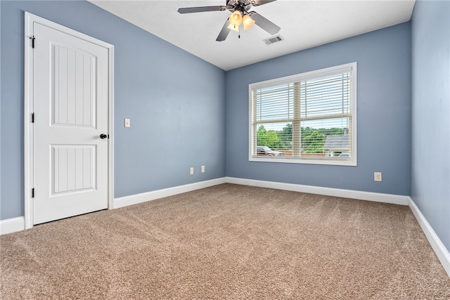 carpeted spare room with baseboards and ceiling fan