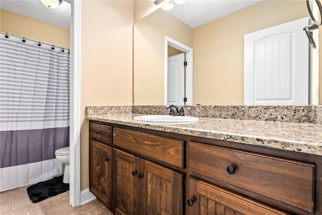 bathroom featuring toilet, vanity, tile patterned flooring, and curtained shower