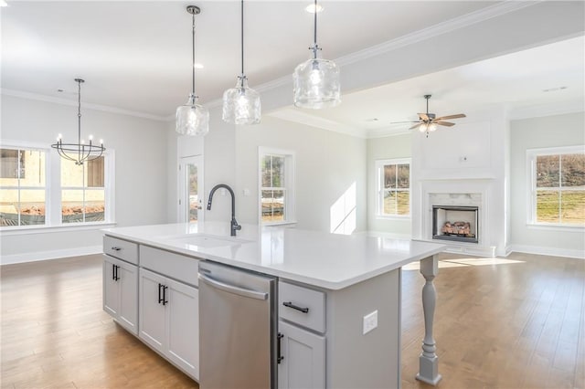 kitchen with dishwasher, sink, a kitchen island with sink, and decorative light fixtures