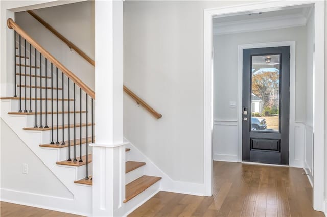 entrance foyer with hardwood / wood-style flooring and crown molding