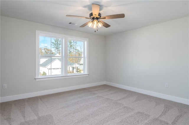 carpeted spare room featuring ceiling fan