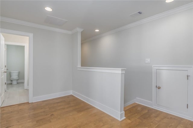 empty room with light hardwood / wood-style floors and crown molding