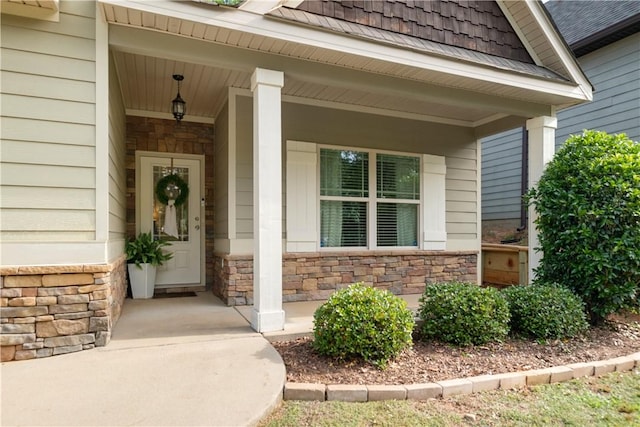 property entrance featuring stone siding and covered porch