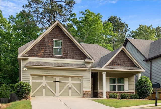 craftsman-style house with an attached garage, a shingled roof, a front lawn, and driveway