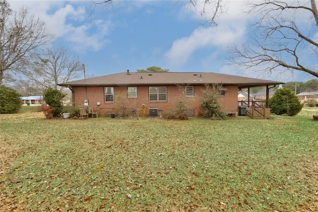 back of house featuring central AC and a yard