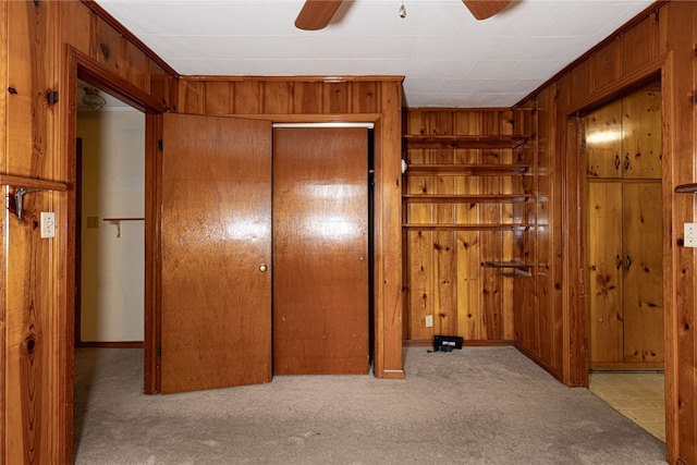 corridor with light carpet and wood walls