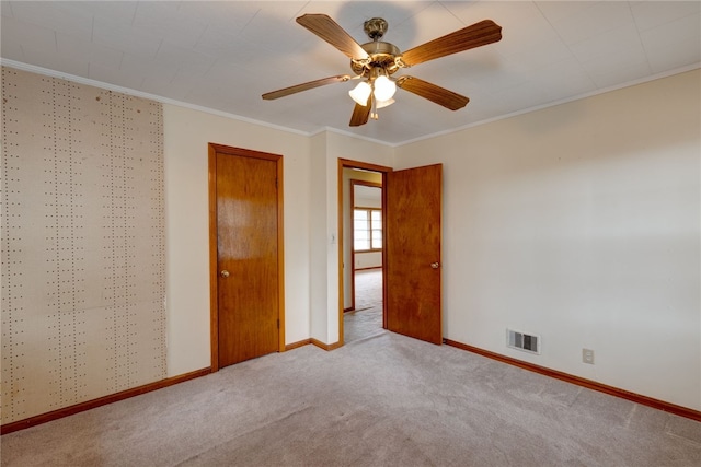 unfurnished bedroom with ceiling fan, light colored carpet, and ornamental molding