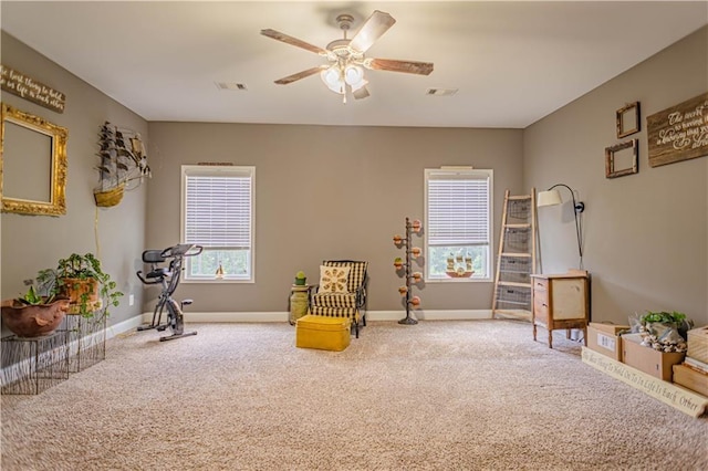 sitting room featuring carpet flooring, a wealth of natural light, and ceiling fan