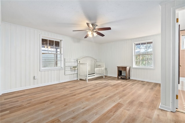 unfurnished bedroom featuring a textured ceiling, ceiling fan, and light wood-type flooring