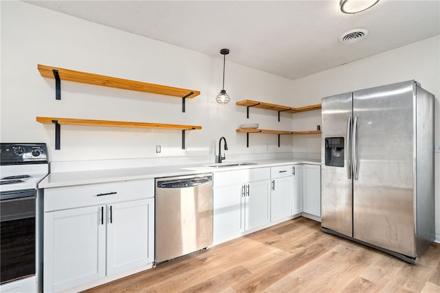 kitchen with appliances with stainless steel finishes, decorative light fixtures, sink, and white cabinets