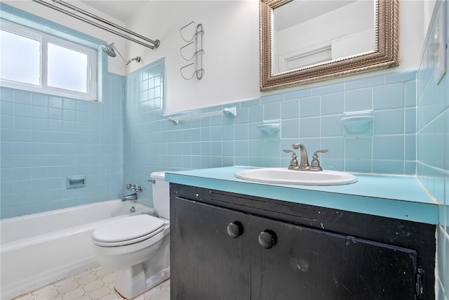 full bathroom with tile walls, vanity, tiled shower / bath, tile patterned floors, and toilet