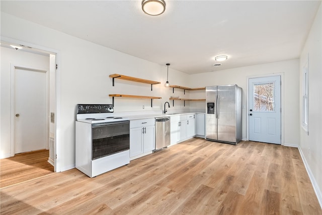 kitchen featuring pendant lighting, sink, white cabinetry, stainless steel appliances, and light hardwood / wood-style floors