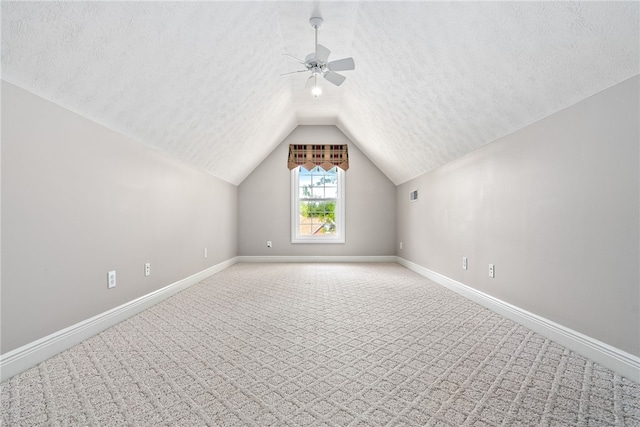 bonus room featuring a textured ceiling, vaulted ceiling, baseboards, ceiling fan, and carpet floors