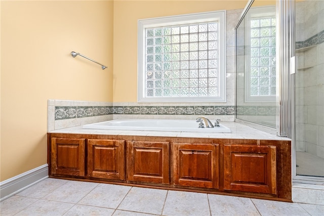 bathroom featuring a bath, tile patterned flooring, and a shower stall
