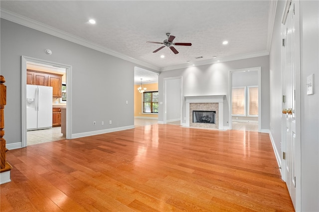 unfurnished living room with recessed lighting, light wood-style floors, ceiling fan with notable chandelier, crown molding, and a fireplace