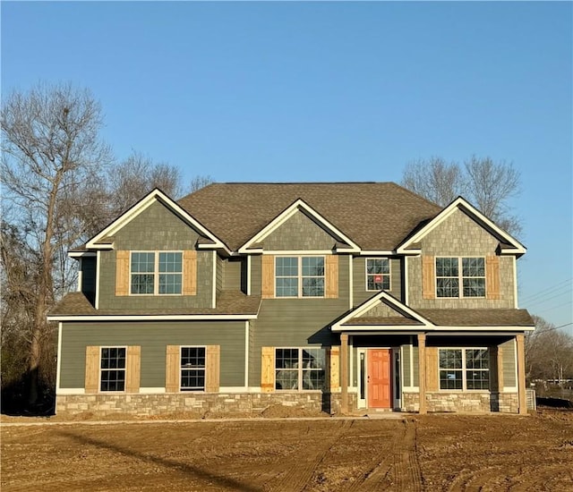 craftsman house with stone siding and a shingled roof