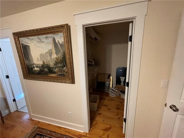 hall with light wood-type flooring and a wall unit AC