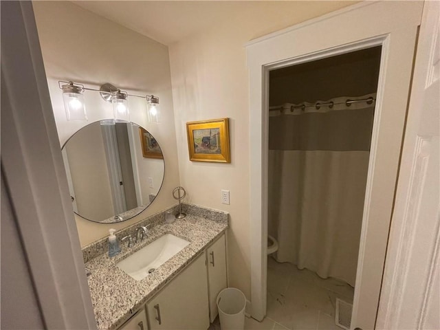 bathroom featuring tile patterned flooring, vanity, and toilet