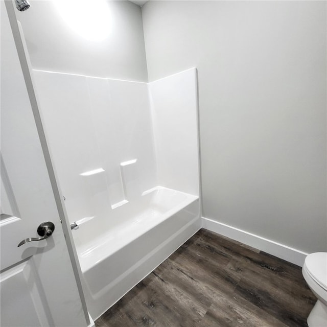 bathroom featuring  shower combination, toilet, and hardwood / wood-style floors