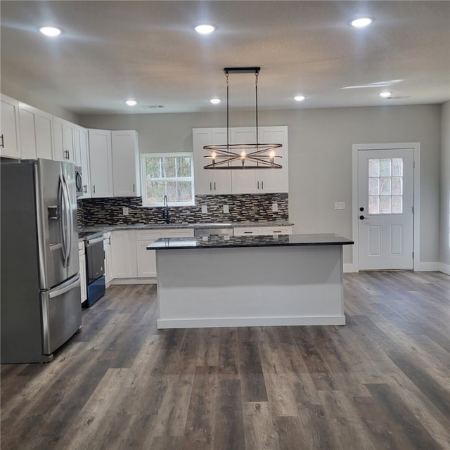 kitchen featuring stainless steel refrigerator with ice dispenser, a center island, electric range oven, pendant lighting, and white cabinets