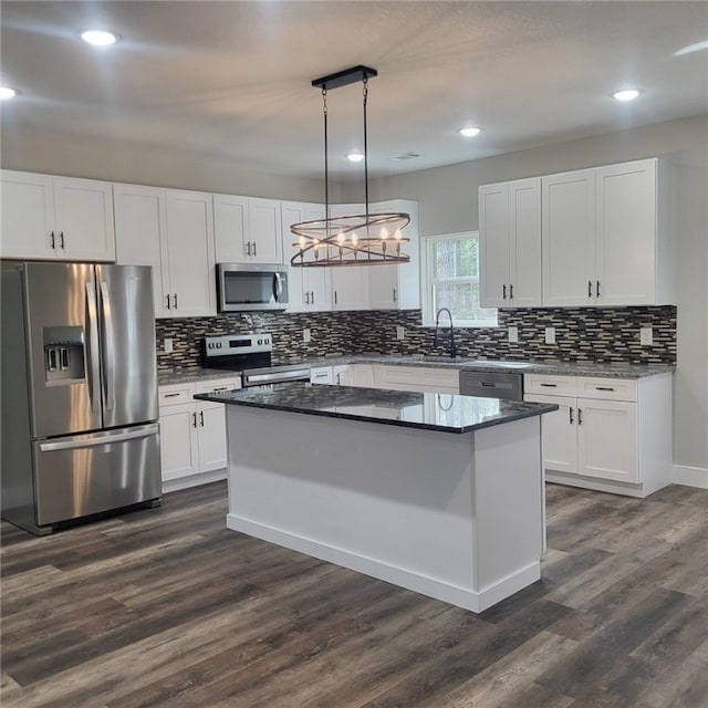 kitchen featuring appliances with stainless steel finishes, a kitchen island, hanging light fixtures, and white cabinets