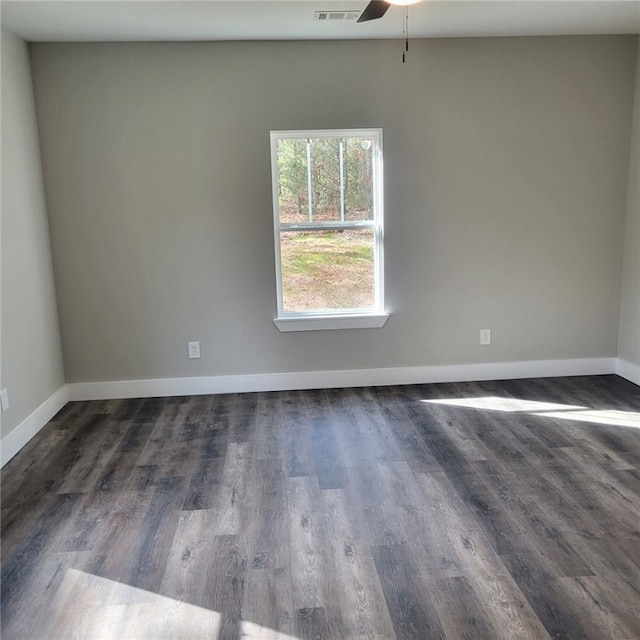 spare room featuring dark wood-type flooring and ceiling fan